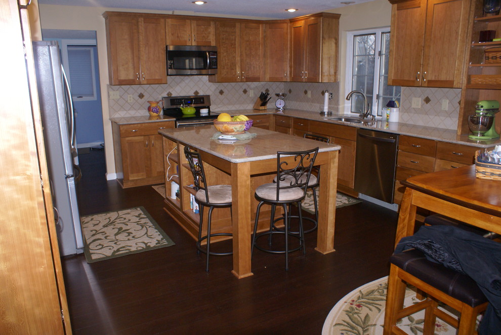 Example of a transitional l-shaped eat-in kitchen design in Indianapolis with an undermount sink, recessed-panel cabinets, light wood cabinets, granite countertops and stainless steel appliances