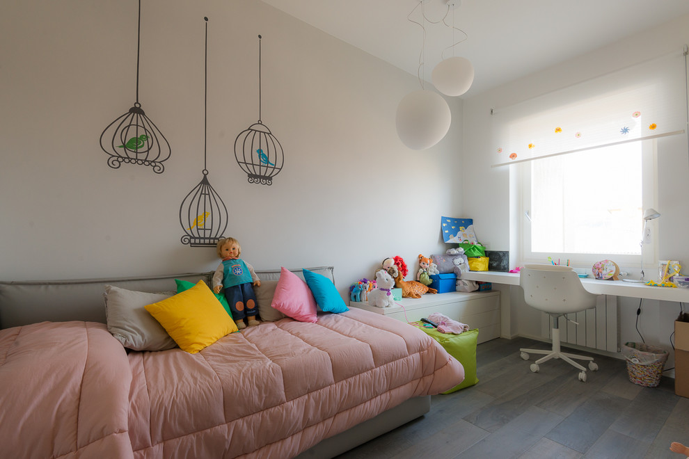 Photo of a large contemporary kids' bedroom for kids 4-10 years old and girls in Milan with white walls and dark hardwood floors.