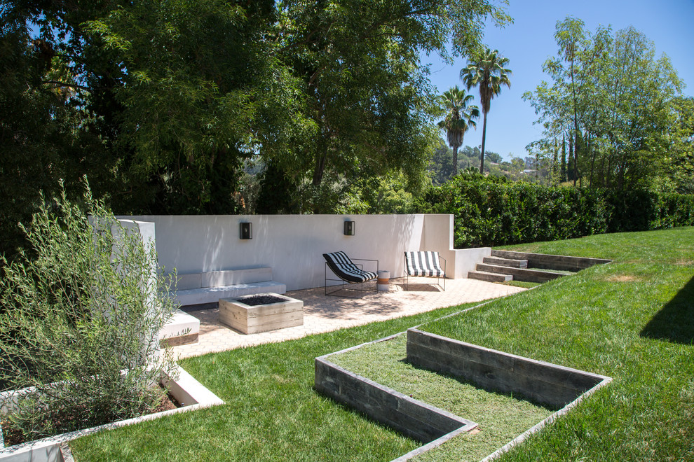 Inspiration for a mid-sized transitional backyard patio in Los Angeles with concrete slab and a roof extension.