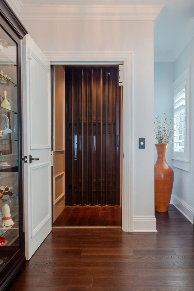 Design ideas for a beach style hallway in Tampa with white walls, dark hardwood floors and brown floor.