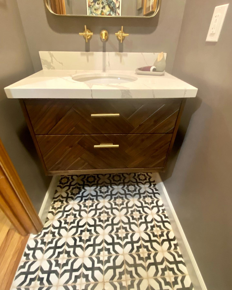 Bild på ett litet eklektiskt vit vitt badrum, med möbel-liknande, bruna skåp, en vägghängd toalettstol, grå väggar, mosaikgolv, ett undermonterad handfat, bänkskiva i kvarts och flerfärgat golv
