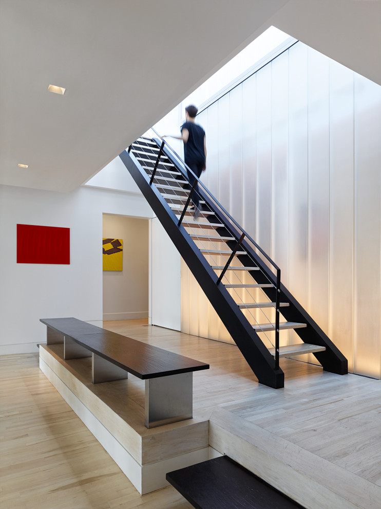 Photo of a contemporary straight staircase in New York with open risers and cable railing.