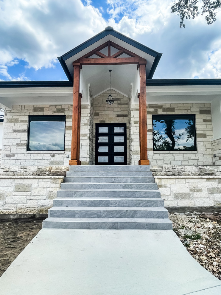 Huge transitional white one-story stone house exterior photo with a hip roof, a metal roof and a black roof