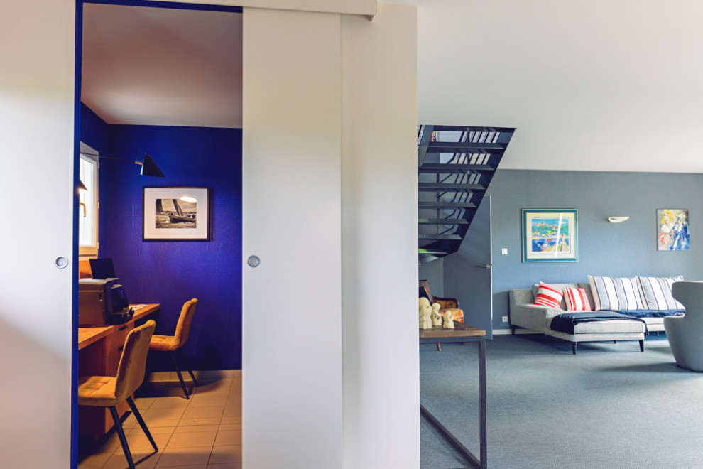 Diseño de despacho actual de tamaño medio con paredes azules, suelo de baldosas de cerámica, escritorio empotrado, suelo gris y papel pintado