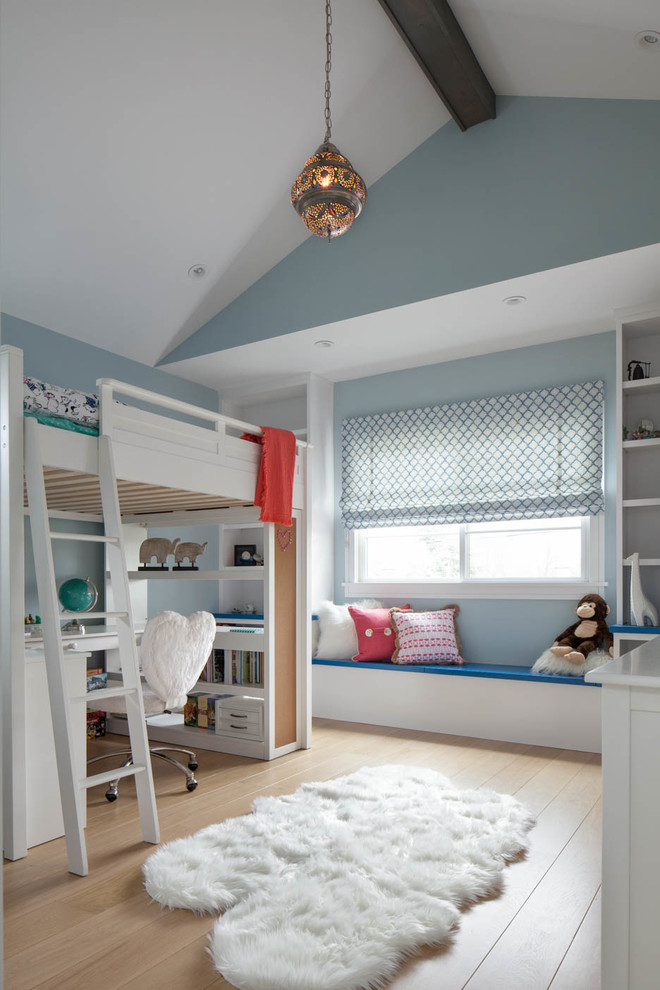 Photo of a transitional kids' room for girls in San Francisco with blue walls and light hardwood floors.