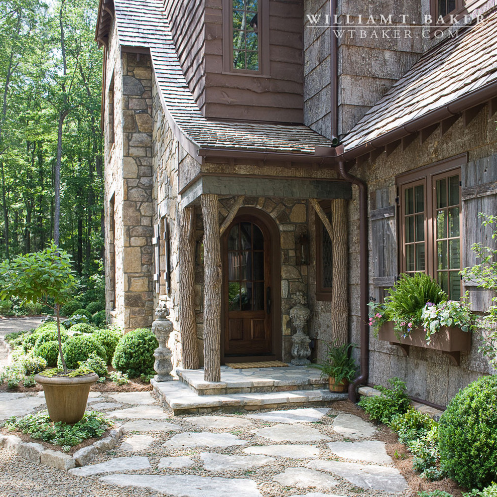 Design ideas for a large country two-storey brown exterior in Atlanta with stone veneer and a gable roof.