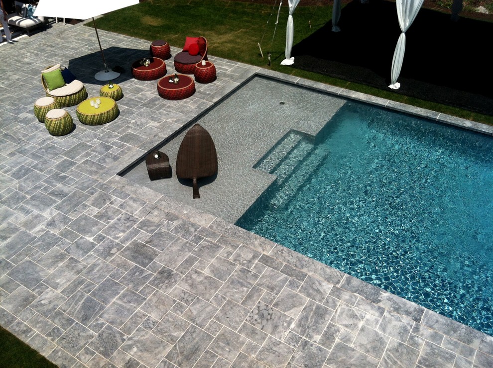 Large backyard stone and rectangular lap hot tub photo in New York