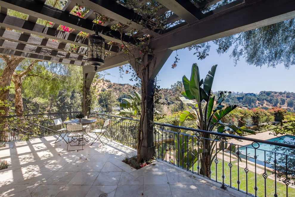 Inspiration for a mediterranean balcony in Los Angeles with a pergola and metal railing.