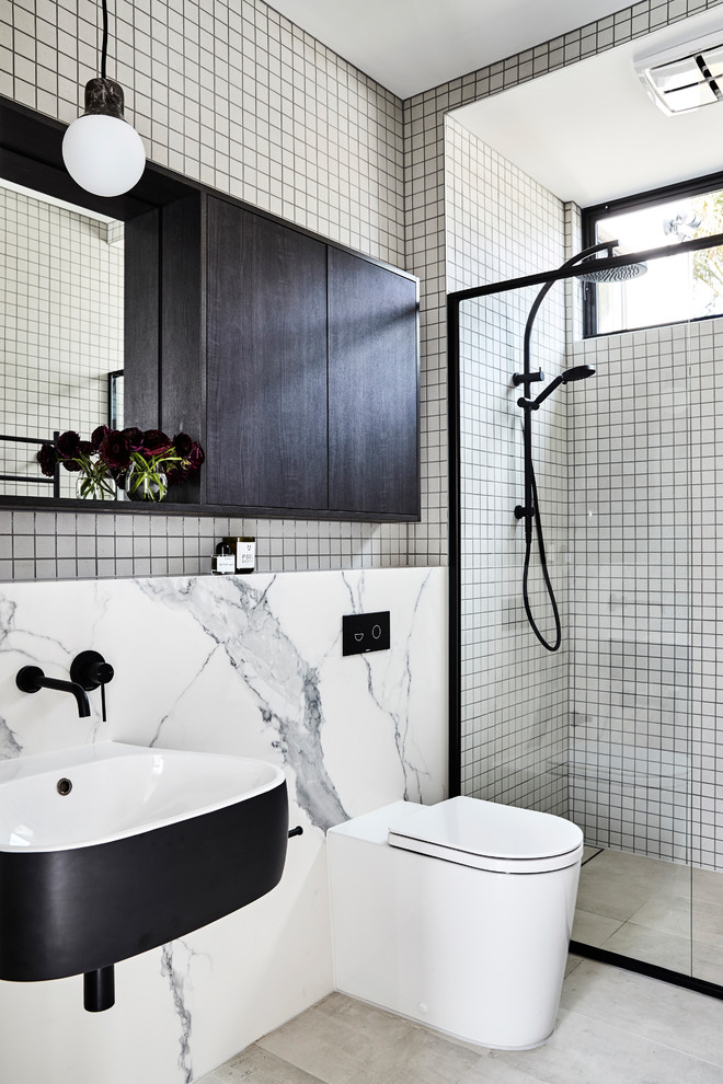 Contemporary 3/4 bathroom in Sydney with flat-panel cabinets, light wood cabinets, an alcove shower, a one-piece toilet, white tile, white walls, a wall-mount sink, grey floor and a hinged shower door.