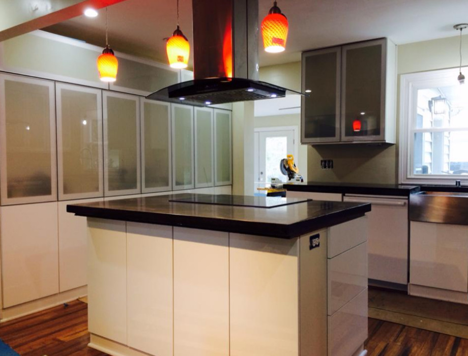 Mid-sized galley painted wood floor eat-in kitchen photo with white cabinets, green backsplash, ceramic backsplash, stainless steel appliances and an island