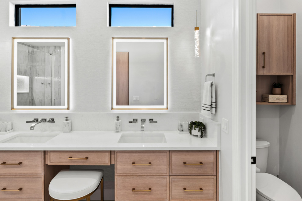 Inspiration for a transitional master gray tile and porcelain tile porcelain tile, white floor and double-sink walk-in shower remodel with shaker cabinets, light wood cabinets, a two-piece toilet, white walls, an undermount sink, quartz countertops, white countertops, a niche and a built-in vanity