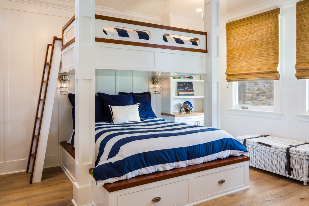 Photo of a mid-sized beach style loft-style bedroom in San Diego with white walls, light hardwood floors and grey floor.