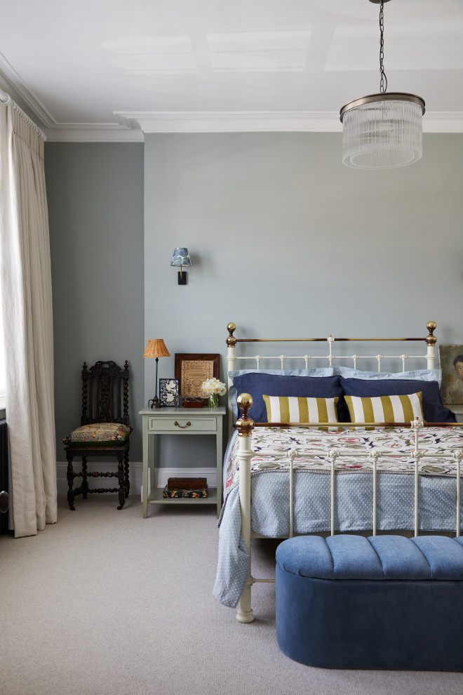 Hauptschlafzimmer mit blauer Wandfarbe, Teppichboden und beigem Boden in London