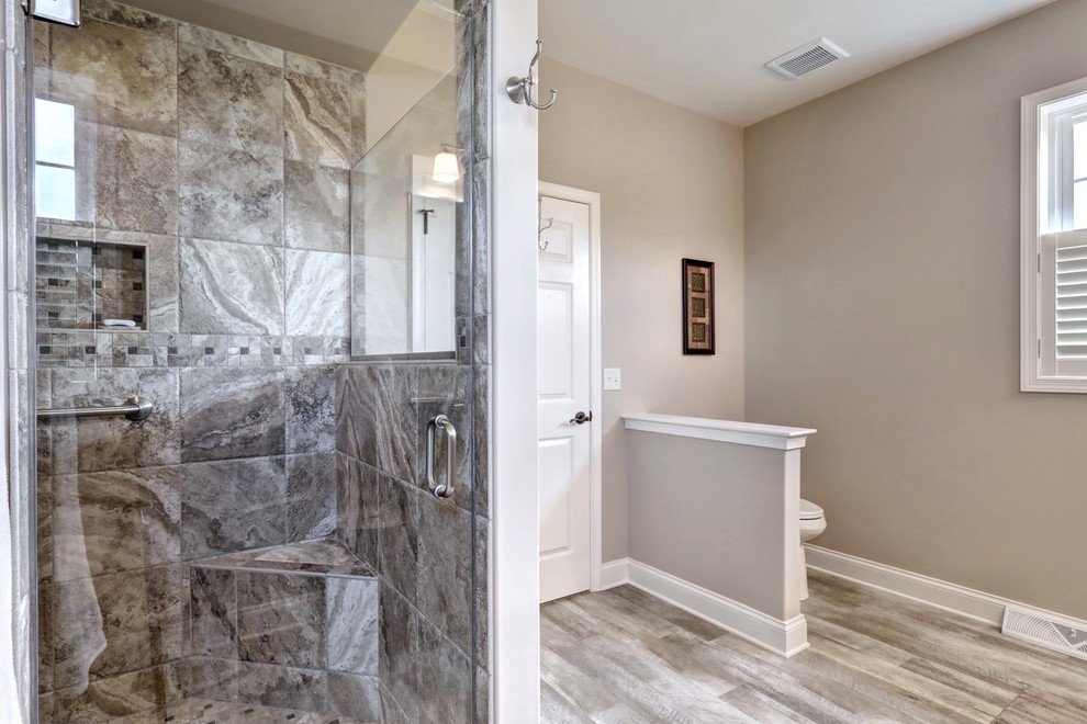 Design ideas for a mid-sized traditional master bathroom in Other with recessed-panel cabinets, grey cabinets, an open shower, a one-piece toilet, gray tile, ceramic tile, beige walls, vinyl floors, an undermount sink, granite benchtops, beige floor and a hinged shower door.