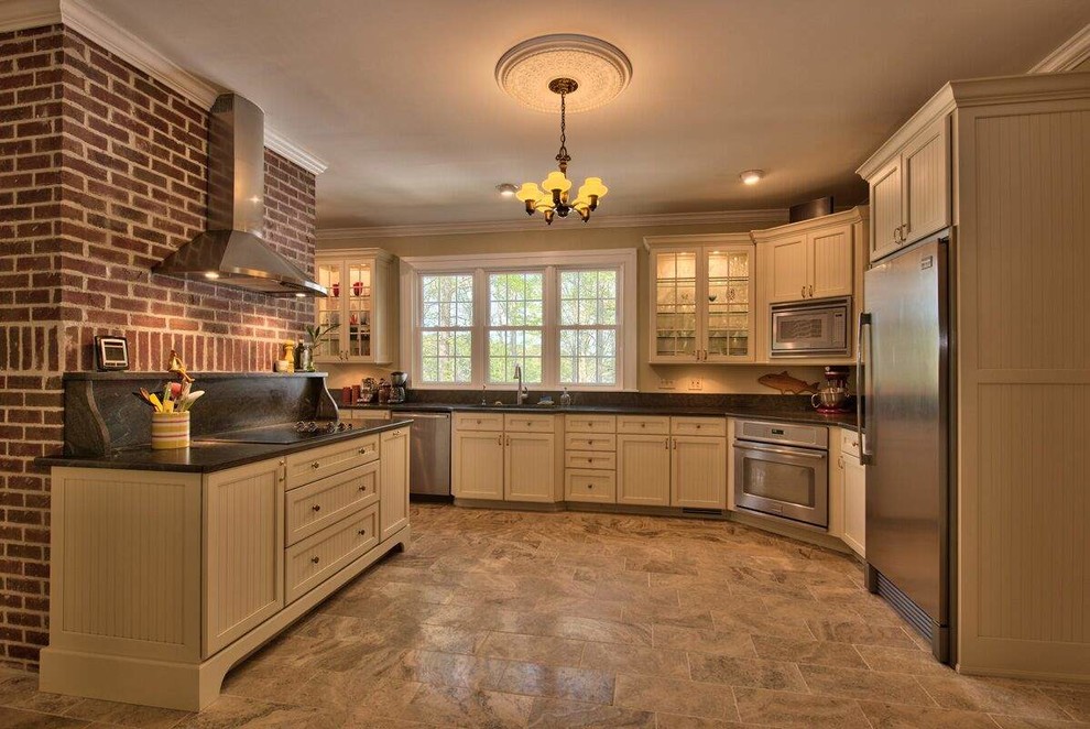 Photo of a country u-shaped kitchen in Atlanta with beige cabinets, granite benchtops and stainless steel appliances.