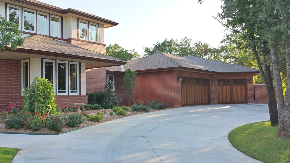 This is an example of a mid-sized traditional two-storey brick red exterior in Oklahoma City with a hip roof.