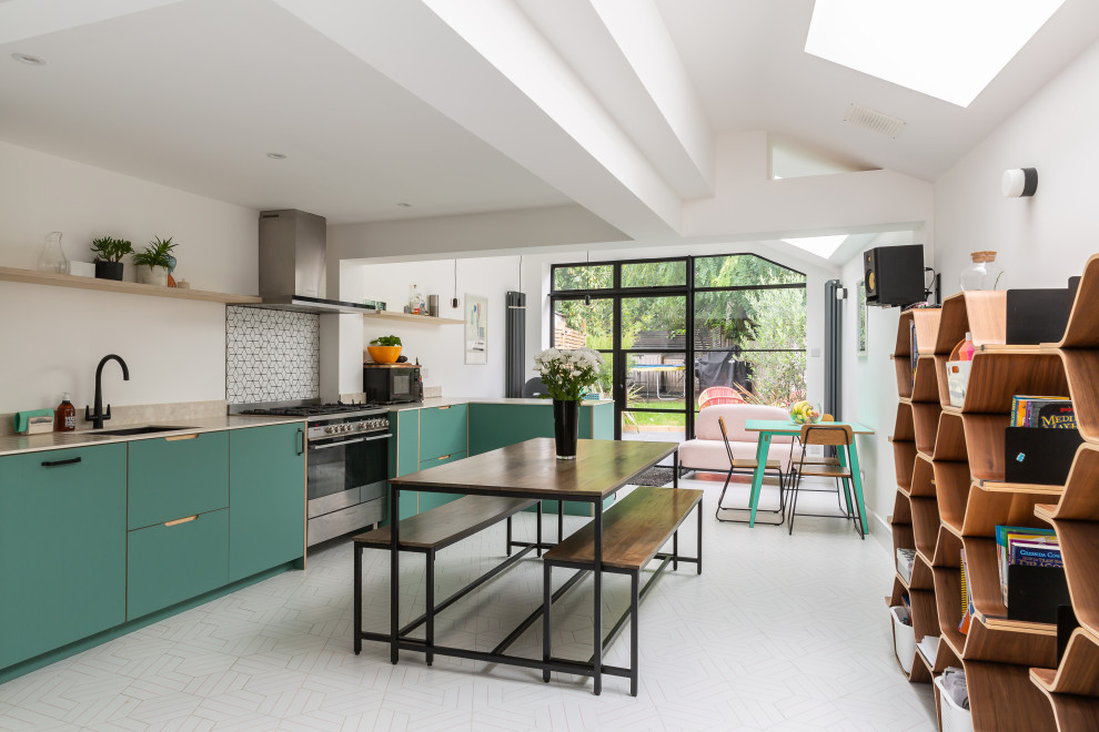 Moderne Wohnküche ohne Insel in L-Form mit Unterbauwaschbecken, flächenbündigen Schrankfronten, grünen Schränken, Küchengeräten aus Edelstahl, weißem Boden und beiger Arbeitsplatte in London