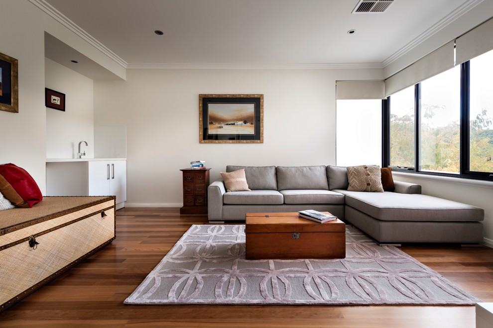 This is an example of a small contemporary enclosed living room in Perth with a library, white walls, medium hardwood floors, no fireplace and brown floor.