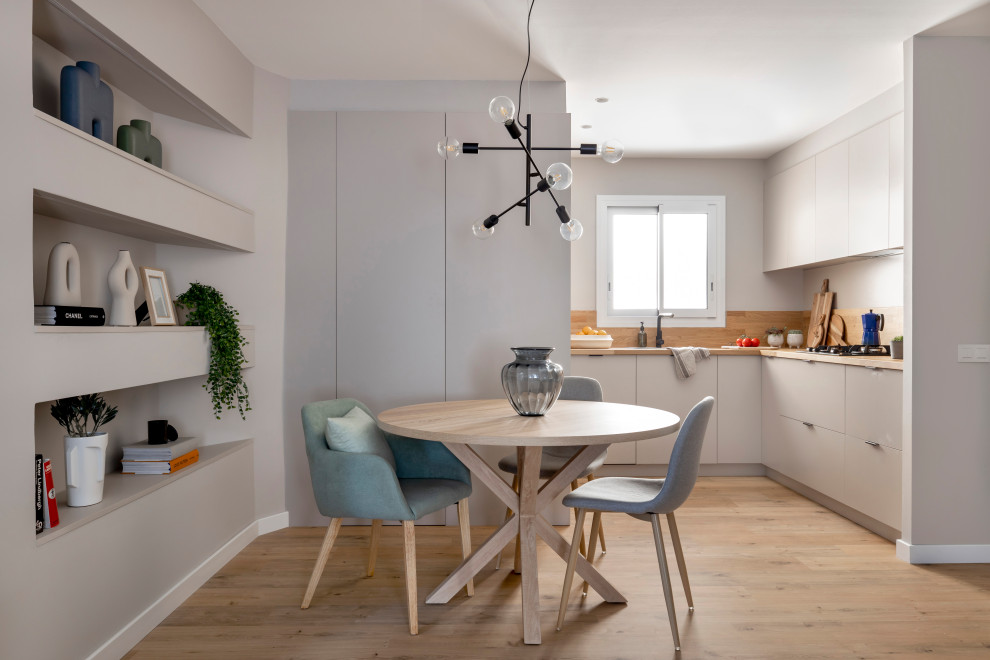 This is an example of a mid-sized scandinavian u-shaped eat-in kitchen in Barcelona with a drop-in sink, flat-panel cabinets, grey cabinets, wood benchtops, timber splashback, stainless steel appliances, medium hardwood floors and no island.