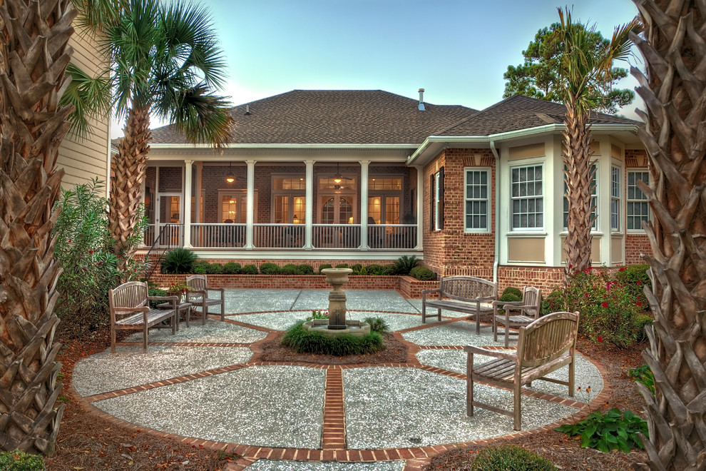 Traditional patio in Charleston with a water feature and brick pavers.