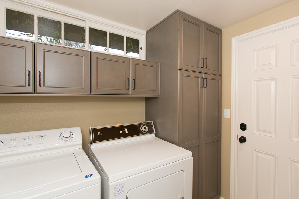 Design ideas for a small transitional single-wall dedicated laundry room in Orange County with recessed-panel cabinets, beige walls, porcelain floors, a side-by-side washer and dryer and brown cabinets.