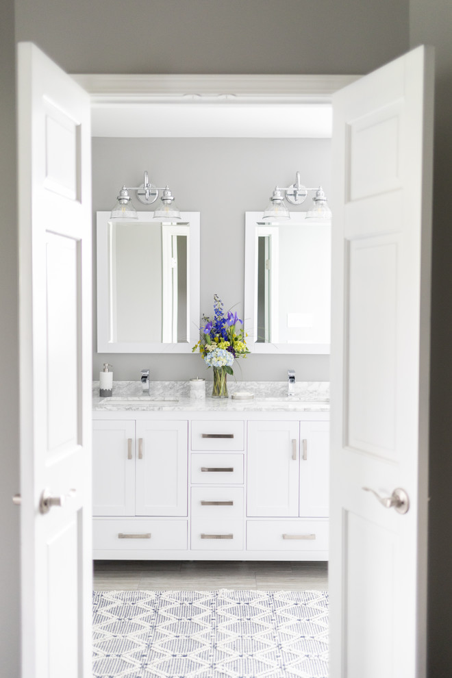 Inspiration for a mid-sized transitional master bathroom in Chicago with shaker cabinets, yellow cabinets, a freestanding tub, an open shower, a two-piece toilet, gray tile, ceramic tile, grey walls, ceramic floors, an undermount sink, marble benchtops, grey floor, an open shower and white benchtops.