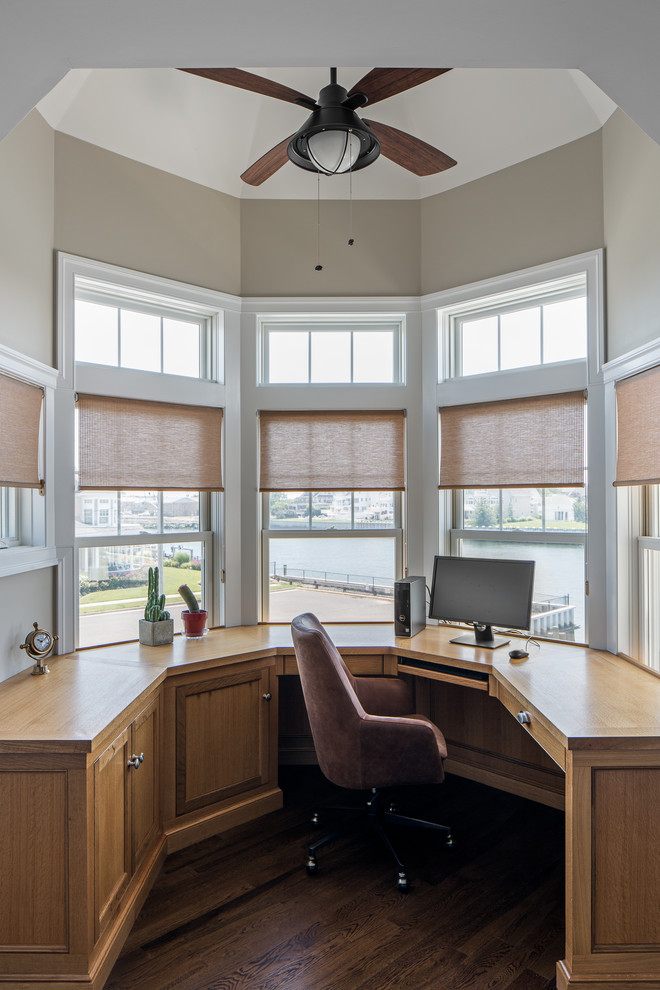 Inspiration for a coastal built-in desk dark wood floor and brown floor study room remodel with beige walls and no fireplace
