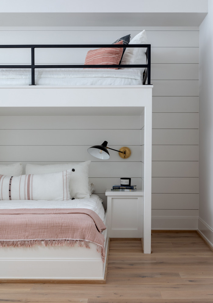 This is an example of an expansive contemporary gender-neutral kids' bedroom in Houston with white walls, light hardwood floors, brown floor, vaulted and planked wall panelling.