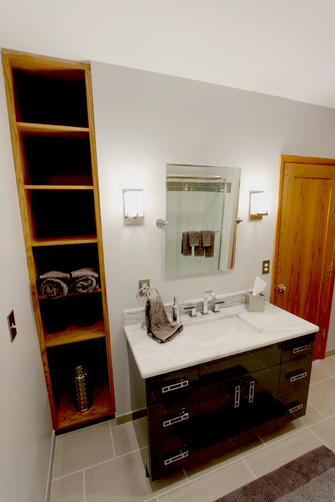 Photo of a small contemporary bathroom in Cleveland with an undermount sink, flat-panel cabinets, grey cabinets, granite benchtops, an alcove tub, an alcove shower, gray tile, ceramic tile, grey walls and ceramic floors.