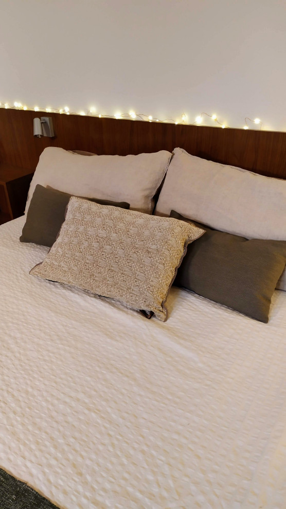 Diseño de dormitorio principal, blanco y beige y blanco actual con paredes blancas, suelo de madera en tonos medios y techo inclinado