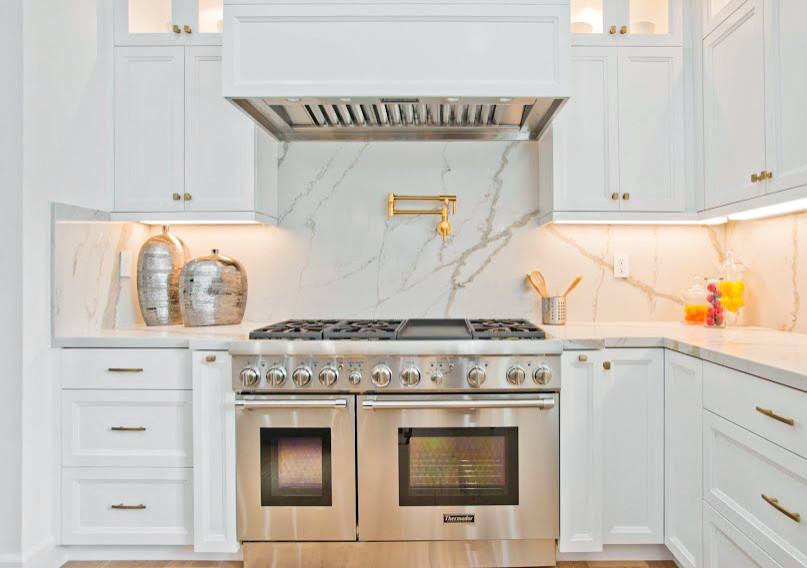 ロサンゼルスにあるラグジュアリーな広いトランジショナルスタイルのおしゃれなキッチン (エプロンフロントシンク、シェーカースタイル扉のキャビネット、白いキャビネット、クオーツストーンカウンター、白いキッチンパネル、クオーツストーンのキッチンパネル、シルバーの調理設備、淡色無垢フローリング、黄色い床、白いキッチンカウンター、塗装板張りの天井) の写真