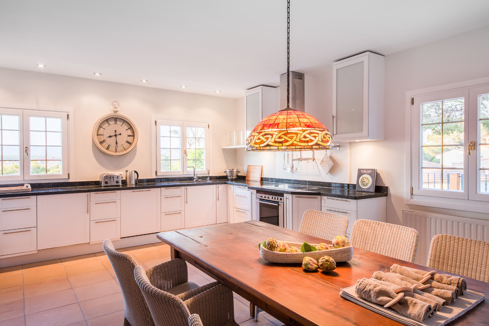 Eat-in kitchen - large transitional l-shaped ceramic tile eat-in kitchen idea with a single-bowl sink, flat-panel cabinets, white cabinets, white backsplash, stainless steel appliances and no island