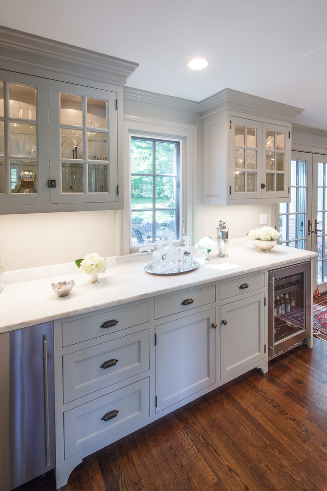 Large transitional l-shaped dark wood floor kitchen photo in Boston with a single-bowl sink, beaded inset cabinets, gray cabinets, marble countertops, gray backsplash, stone slab backsplash, paneled appliances and an island