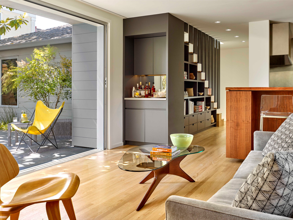 Foto di un soggiorno minimalista con parquet chiaro, angolo bar, pareti bianche e pareti in perlinato