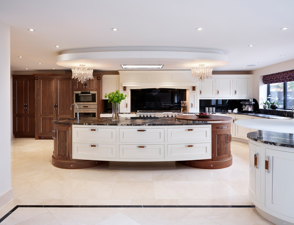 Expansive contemporary open plan kitchen in London with granite benchtops, black splashback, glass sheet splashback, stainless steel appliances and with island.