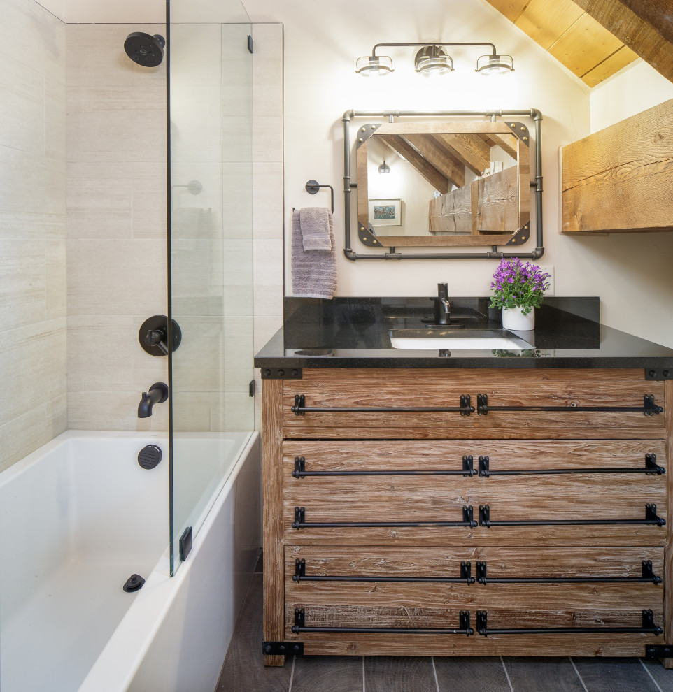 Foto på ett mellanstort rustikt svart badrum med dusch, med bruna skåp, ett badkar i en alkov, vit kakel, porslinskakel, klinkergolv i porslin, ett undermonterad handfat, granitbänkskiva, grått golv, dusch med gångjärnsdörr och släta luckor