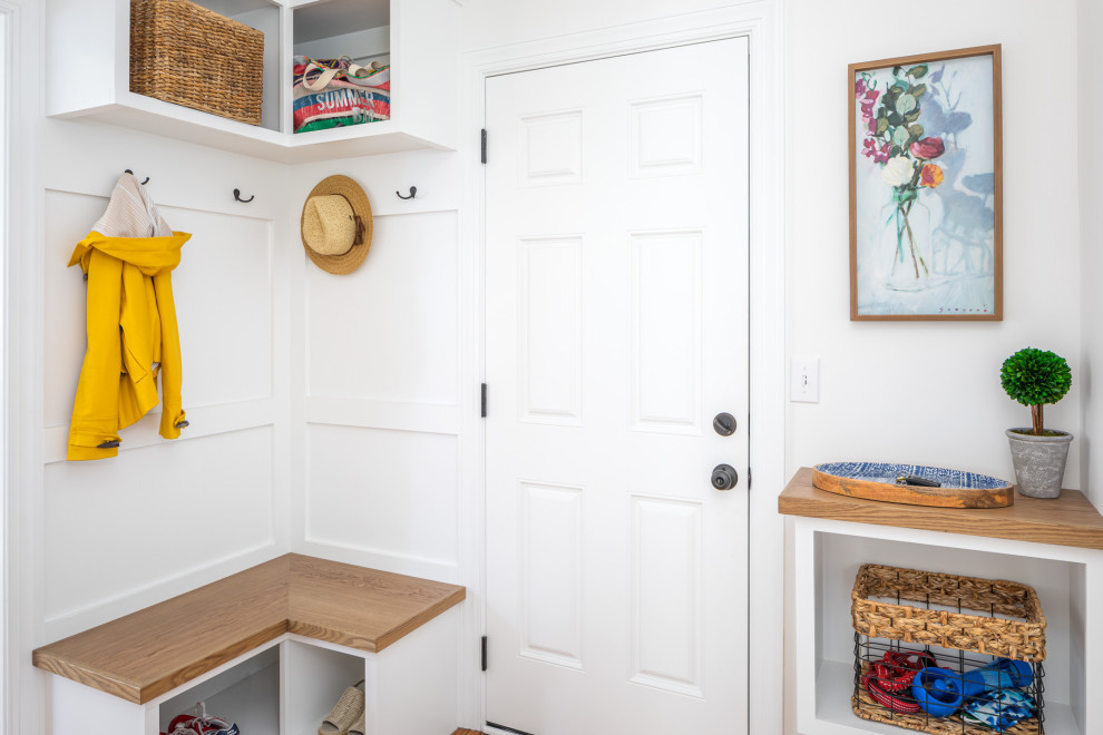 Photo of a small transitional mudroom in Raleigh with white walls, medium hardwood floors, a single front door, a white front door, brown floor and decorative wall panelling.