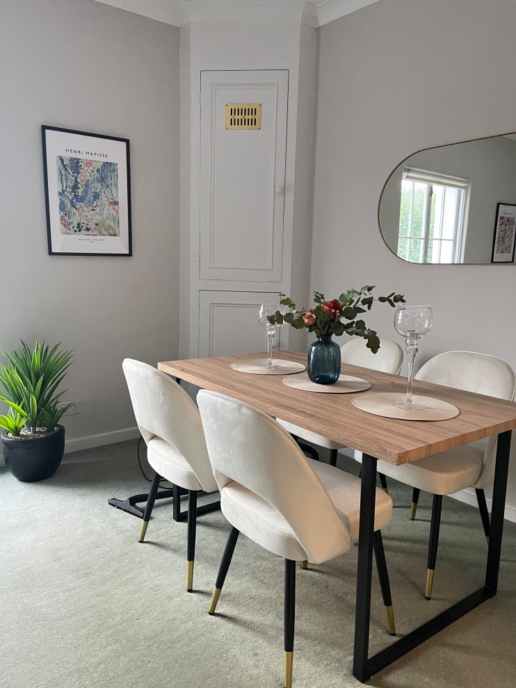 This is an example of a medium sized contemporary dining room in London with grey walls and carpet.