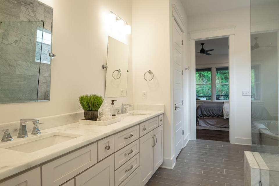Photo of a large transitional master bathroom in Nashville with shaker cabinets, white cabinets, a freestanding tub, a corner shower, white tile, porcelain tile, white walls, porcelain floors, an undermount sink and quartzite benchtops.
