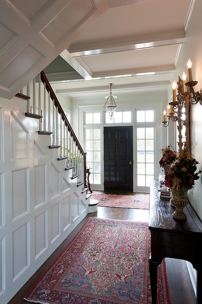 This is an example of a mid-sized traditional foyer in Dallas with a single front door, a black front door, white walls and dark hardwood floors.