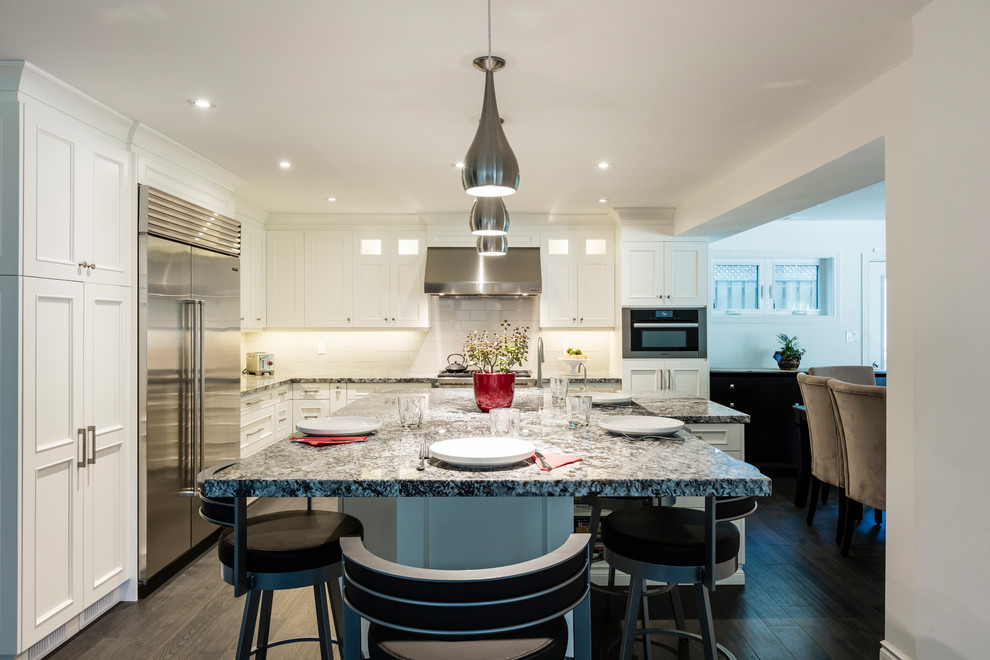 Kitchen - mid-sized transitional l-shaped brown floor kitchen idea in Toronto with white cabinets, stainless steel appliances and an island