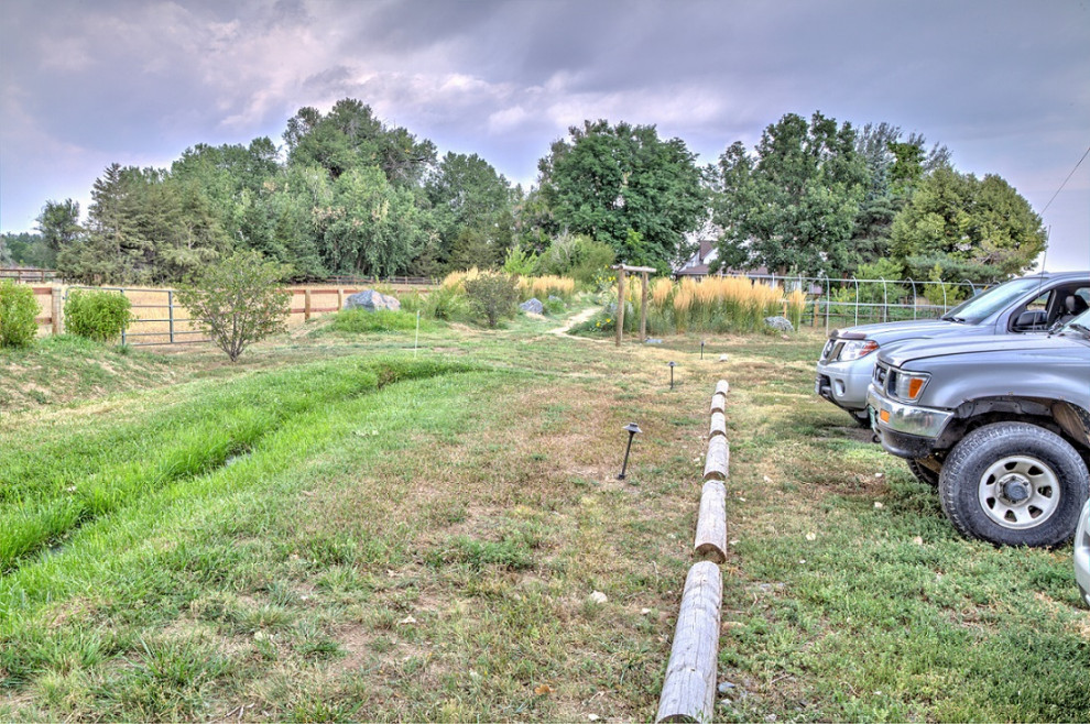 This is an example of an expansive rural front xeriscape full sun garden in Denver with a garden path.