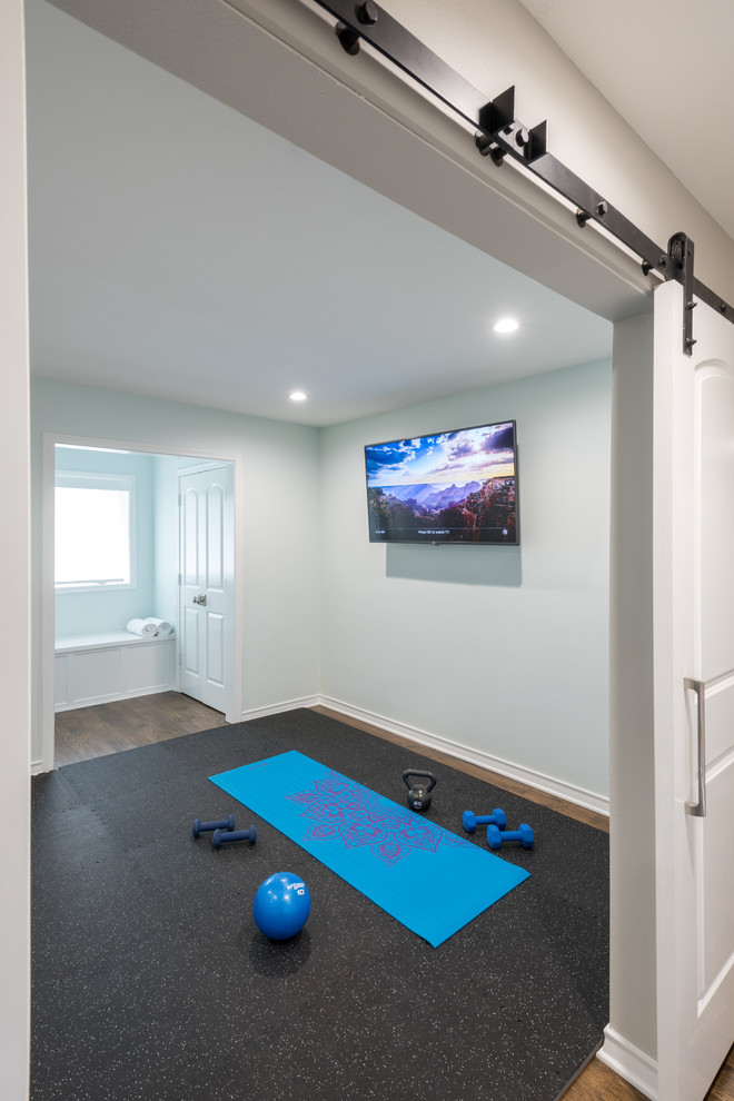 This is an example of a mid-sized transitional multipurpose gym in Dallas with white walls, medium hardwood floors and brown floor.