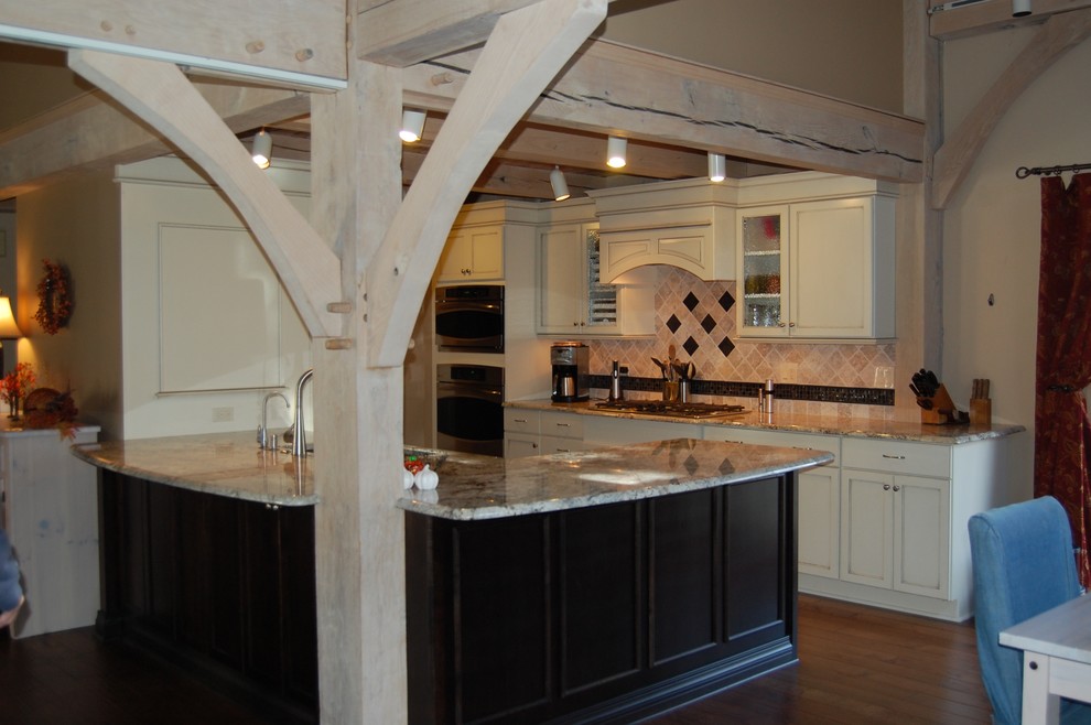 Example of a mid-sized transitional u-shaped medium tone wood floor open concept kitchen design in Chicago with an undermount sink, flat-panel cabinets, dark wood cabinets, granite countertops, beige backsplash, stone tile backsplash, stainless steel appliances and a peninsula