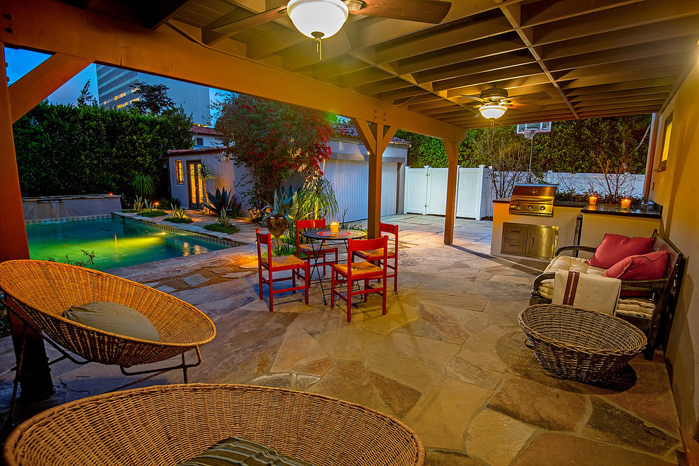 This is an example of a mid-sized mediterranean backyard full sun xeriscape for summer in Los Angeles with natural stone pavers.