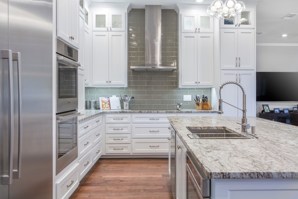 Eat-in kitchen - large transitional l-shaped dark wood floor and brown floor eat-in kitchen idea with an undermount sink, shaker cabinets, white cabinets, granite countertops, beige backsplash, glass tile backsplash, stainless steel appliances, an island and beige countertops