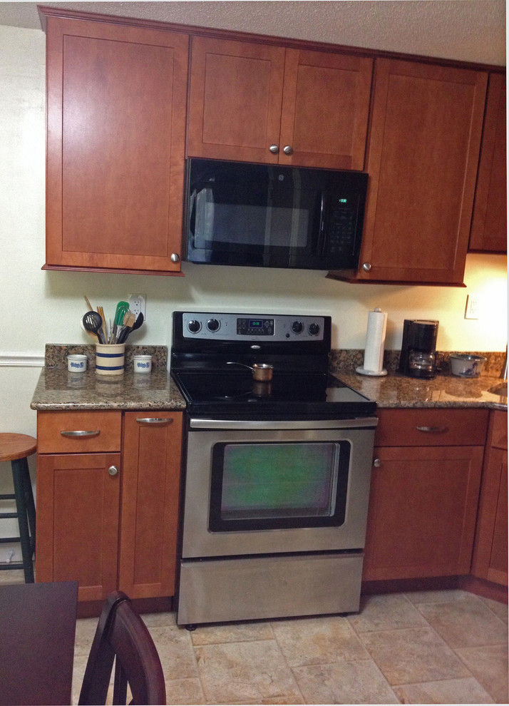 Example of a small transitional l-shaped linoleum floor eat-in kitchen design in Boston with an undermount sink, recessed-panel cabinets, medium tone wood cabinets, granite countertops, stainless steel appliances and no island