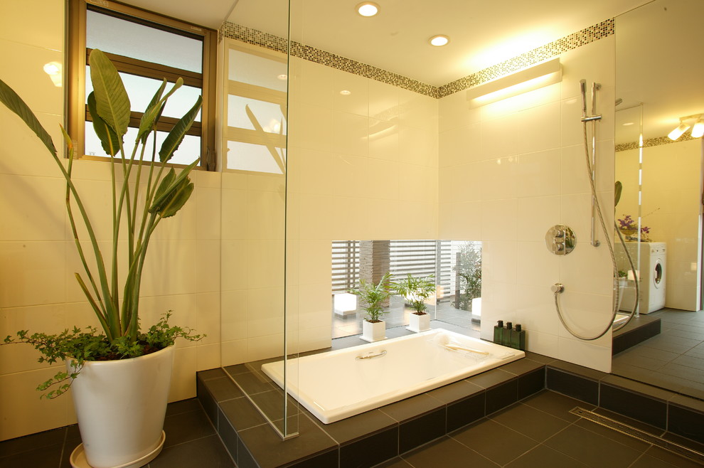 Asian bathroom in Other with a drop-in tub, an open shower, white walls, black floor and an open shower.