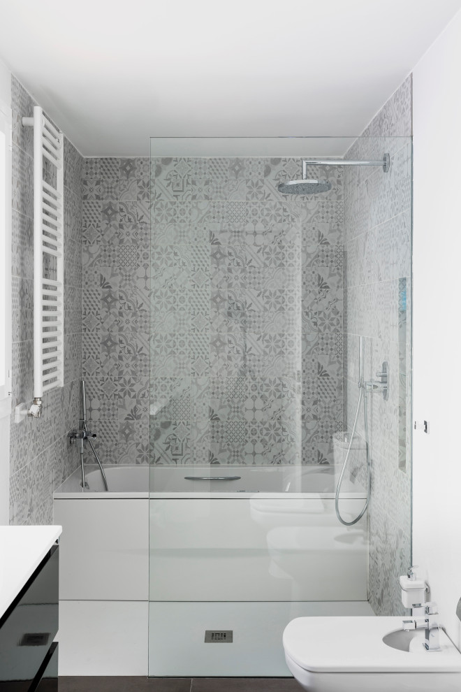 Large modern grey and white ensuite bathroom in Barcelona with flat-panel cabinets, white cabinets, a hot tub, a built-in shower, a two-piece toilet, grey tiles, grey walls, porcelain flooring, a submerged sink, solid surface worktops, grey floors, a sliding door, white worktops, a single sink and a floating vanity unit.