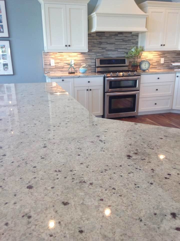 Inspiration for a large transitional medium tone wood floor and brown floor eat-in kitchen remodel in Denver with shaker cabinets, white cabinets, gray backsplash, matchstick tile backsplash, stainless steel appliances, an island and granite countertops